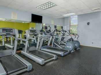 A room filled with cardio equipment and a flat screen tv